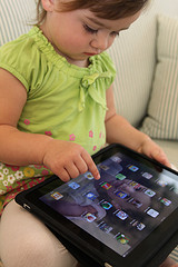A baby sitting in front of an iPad