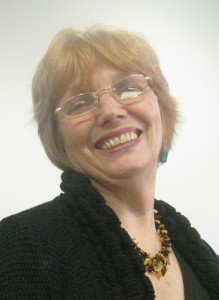 A woman wearing glasses and smiling at the camera