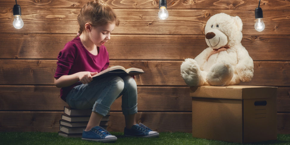 A kid sitting on a bench in front of a stuffed animal