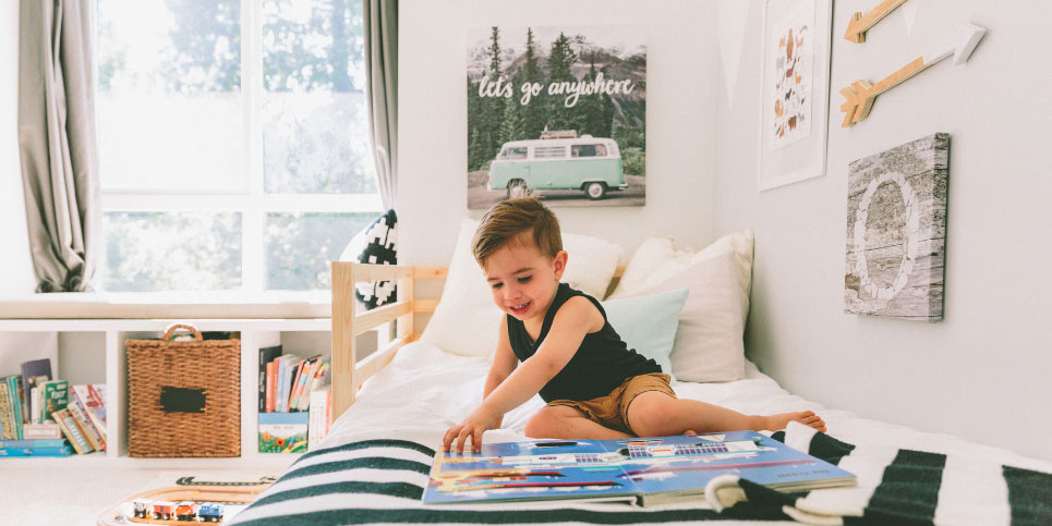 A young boy lying on a bed reading