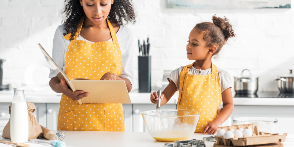 A woman preparing food on a table with child