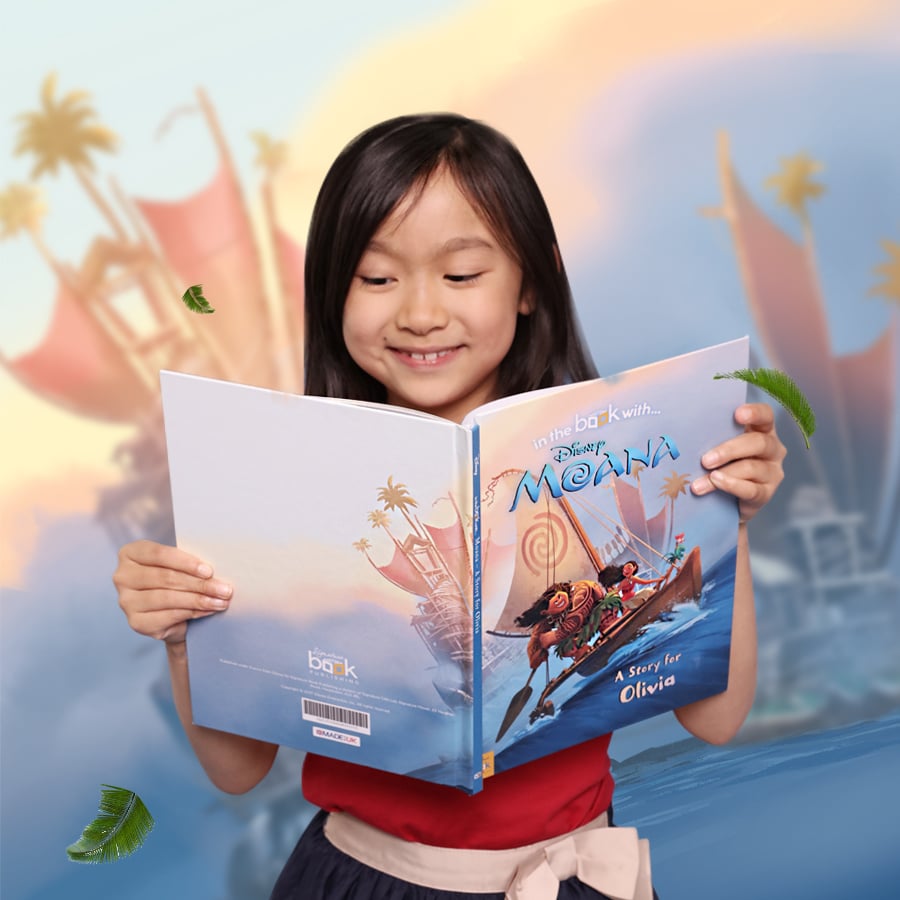 A girl holding a Moana book