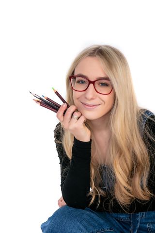 Eleanor Loseby: Illustrator Headshot holding pencils.