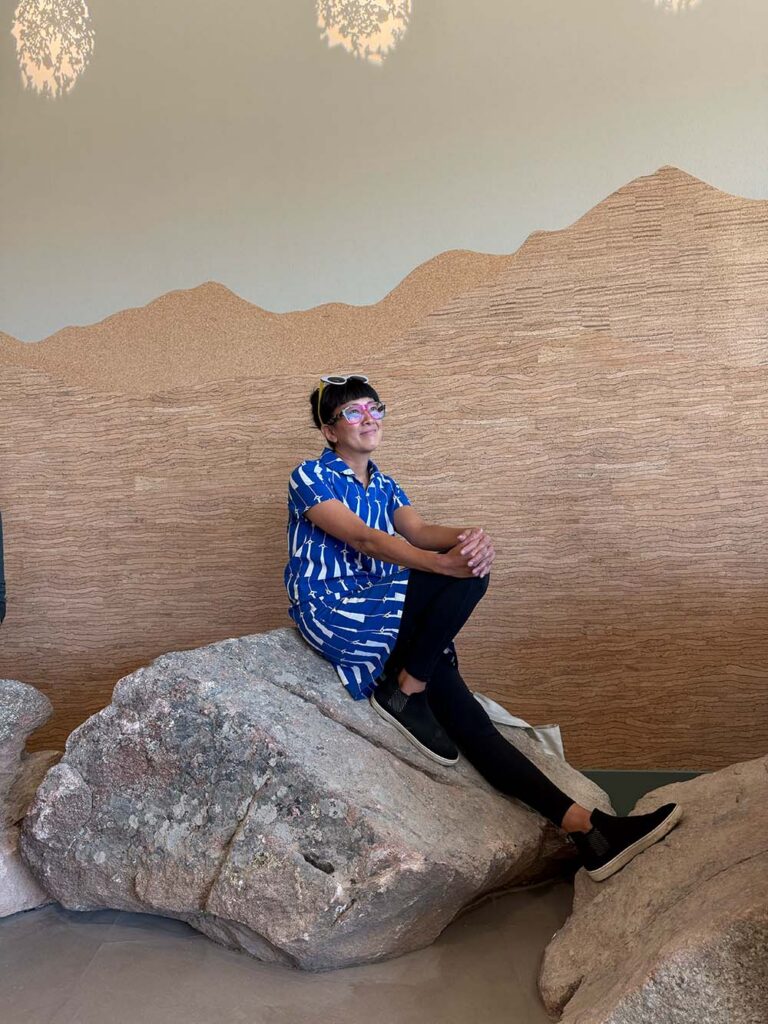 Saki Tanaka | The Children's Book Review Saki Tanaka sitting on granite boulder at Anythink Library